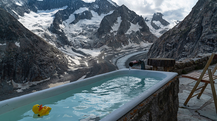 Ice bath with mountain scenery and a yellow rubber duck in the bath tub