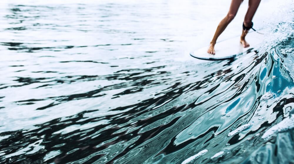 beautiful surfer girl riding board and enjoying the benefits of paddle boarding